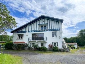 a white house with a gambrel roof at Le Domaine de Rose in Lourdes