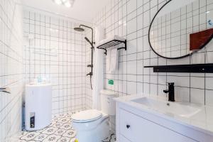 a white bathroom with a toilet and a sink at Beijing Rong Courtyard Boutique Hotel in Beijing +56 photos
