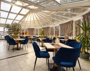 a restaurant with tables and chairs and windows at Hotel Nordkap in Karlshagen