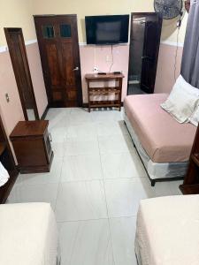 a room with two beds and a desk and a tv at Casa González in Santiago Atitlán