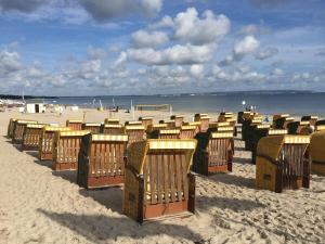 a row of beach chairs on a sandy beach at Ferienhaus Altes Fischerhaus in Binz