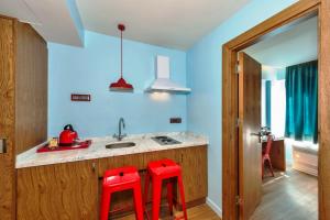 a kitchen with two red stools in front of a sink at Taksim Istanbul Nis Hotel - Istiklal Street in Istanbul +40 photos