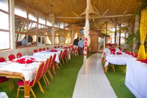 a group of tables in a room with red chairs at Maison du Bonheur in Dakar