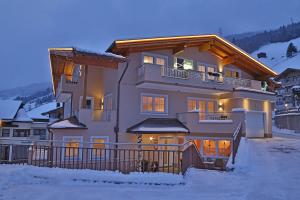 a large house in the snow in the evening at Chalet Lena in Gerlos