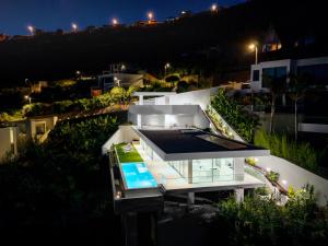 a large white house with a swimming pool at night at Villa Gia in Calheta