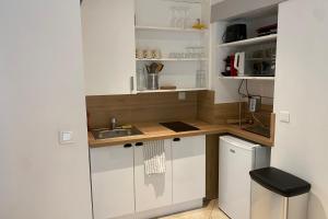 a small kitchen with white cabinets and a sink at Clos Briard - Calme & paisible près Disney & Paris in La Houssaye-en-Brie
