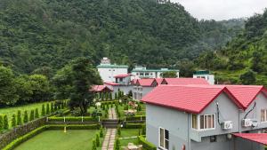 a row of houses with red roofs and a garden at Purna Boutique - Luxury Villa, Private Pool in Bhīm Tāl
