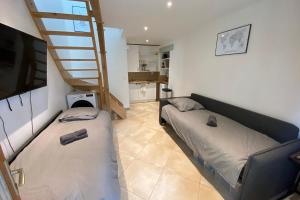 a living room with a bed and a staircase at Clos Briard - Calme & paisible près Disney & Paris in La Houssaye-en-Brie