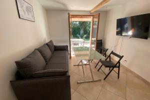 a living room with a couch and a glass table at Clos Briard - Calme & paisible près Disney & Paris in La Houssaye-en-Brie