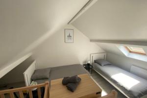 a room with a bed and a table in a attic at Clos Briard - Calme & paisible près Disney & Paris in La Houssaye-en-Brie +11 photos