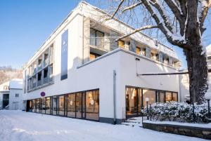 a white building in the snow at Digital Hotel Kronjuwel by BRIGHT Waldkirch - Self Check-In I NIRO in Waldkirch