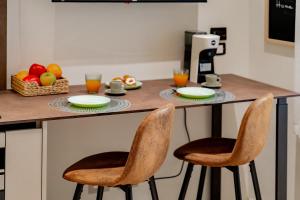 a kitchen with a counter with two chairs and fruits at Le Finestre su Villa d'Este in Tivoli