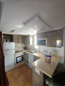 a kitchen with a white refrigerator and a counter at Amazing duplex Las Americas in Costa de Adeje
