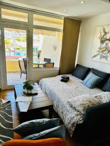 a bedroom with a bed and a table and a window at Amazing duplex Las Americas in Costa de Adeje +20 photos