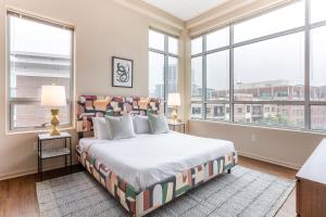a bedroom with a large bed and large windows at Mint House Greenville Downtown By Kasa in Greenville