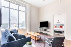 a living room with a couch and a tv at Mint House Greenville Downtown By Kasa in Greenville +44 photos