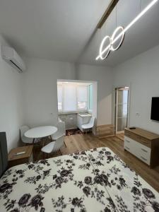 a bedroom with a bed and a table and a desk at E&B Cosy Apartment 6 in Tirana