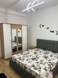 a bedroom with a bed and a chandelier at E&B Cosy Apartment 6 in Tirana