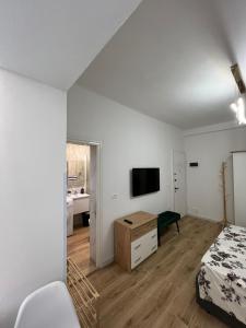 a bedroom with a bed and a tv on a wall at E&B Cosy Apartment 6 in Tirana +4 photos