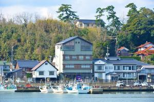 a group of boats docked in a harbor with houses at Yamadaya in Tottori