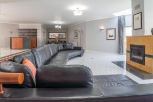 a living room with a leather couch and a fireplace at Villa Atlantica in Setúbal
