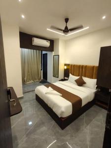 a bedroom with a large bed and a ceiling at Hotel Regal Gate in Mumbai +8 photos