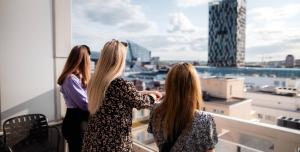three women standing on a balcony looking out at a city at Lapland Hotels Tampere in Tampere