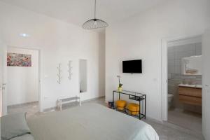 a white bedroom with a bed and a bathroom at GRIMALDI ROOMS Costa d'Amalfi in Pagani