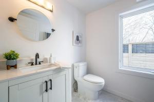 a white bathroom with a toilet and a mirror at 4Br 3 Bath Oceanview Modern Home in Halifax