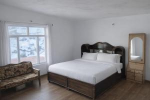 a bedroom with a bed and a chair and a mirror at Mayadeep Resort and Hostels in Chopta