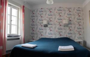 a bedroom with a blue bed with two towels on it at Drottning Victorias Örlogshem in Stockholm