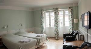 a bedroom with a bed and a chair and a window at Drottning Victorias Örlogshem in Stockholm
