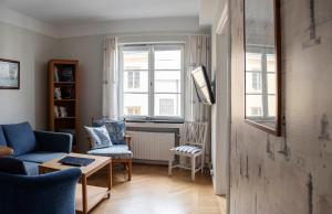 a living room with a blue couch and a tv at Drottning Victorias Örlogshem in Stockholm