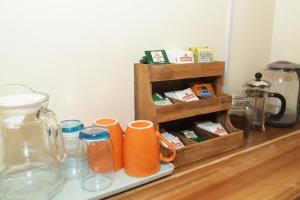a counter with two orange cups and a spice rack at Azuls Tourist Inn in San Vicente +19 photos