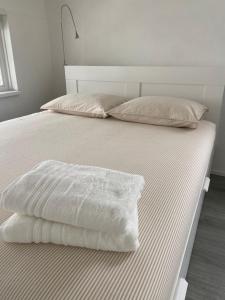 a bed with white blankets and pillows on it at De Keizersmantel in Son