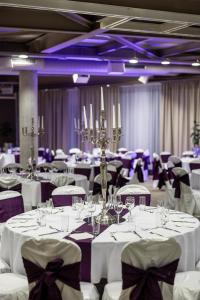 a banquet hall with white tables and purple chairs at Nobel Zira Hotel in Belgrade