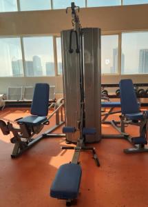 a gym with several blue chairs in a room with windows at Panoramic Sea apartment & Skyline View Private Room in Sharjah +8 photos