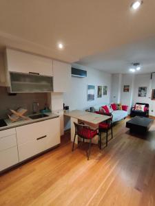 a kitchen and living room with a table and a couch at Pleno centro, 5 minutos Casco Vello, 400 metros estación AVE in Vigo +34 photos