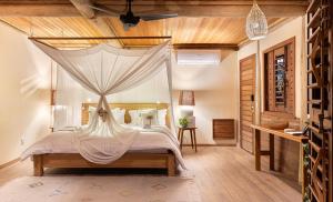 a bedroom with a bed with a mosquito net at Sempre Vivo in Pipa +36 photos