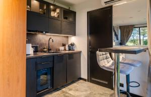 a kitchen with black cabinets and a bar with a stool at Luxury Resort Kabuna in Kabuna