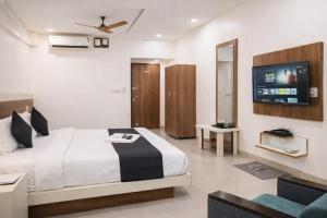 a bedroom with a bed and a flat screen tv at Stay Prime, Balewadi in Pune