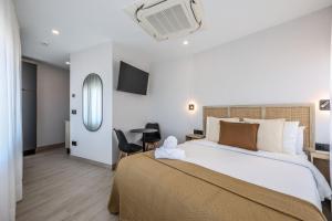 a bedroom with a large white bed and a desk at Password to Malasaña in Madrid