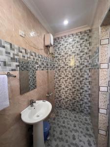 a bathroom with a sink and a shower at PhyllenHotel Tanga in Tanga