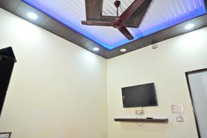 a tv on a wall with a blue ceiling at Royal Mac Palace in Motīhāri