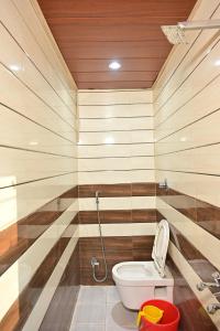 a bathroom with a toilet in a room with striped walls at Royal Mac Palace in Motīhāri