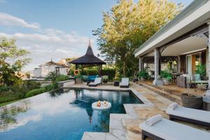 a swimming pool with a gazebo next to a house at Heritage The Villas in Bel Ombre