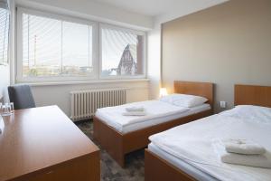 a hotel room with two beds and a window at Hotel Veronika in Ostrava