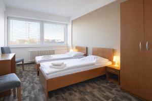 a bedroom with two beds and a desk and a window at Hotel Veronika in Ostrava +61 photos