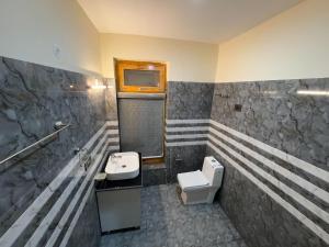 a bathroom with a sink and a toilet and a tv at Astro Retreat - Pangong in Man