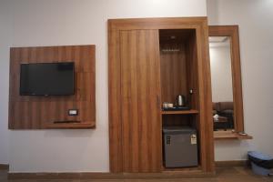 a room with a wooden door with a small television at Hotel Global Inn Gold in Lucknow